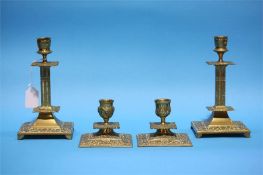 Two pairs of brass candlesticks.