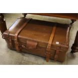 Large brown suitcase with leather mounts and strap