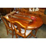 A yew wood dining table and six chairs.