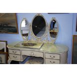 A cream dressing table and stool.