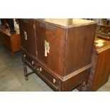 An oak four door drinks cabinet with two drawers,