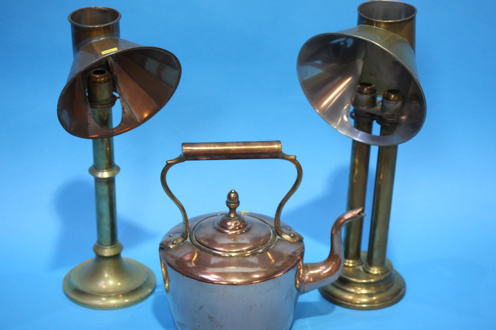 Two brass lamps and a copper kettle.