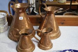 4 Graduated copper jugs