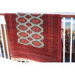 A Pakistani Bokhara rug, the pistachio green ground covered in guls highlighted in madder red, ivory