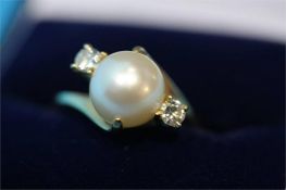 A large pearl and diamond set ring