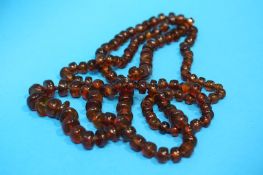 A long string of amber coloured beads