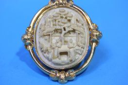 An Oriental cased oval Ivory cameo decorated with figures set in yellow metal mount