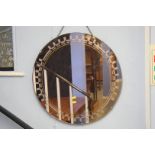 A copper coloured circular mirror