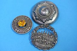Three silver coloured brooches