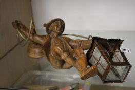A Black Forest carved figure of a boy holding a la