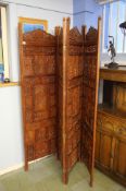 A heavily carved Eastern four fold screen, 181cms