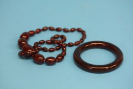 A red amber coloured necklace and a red amber colo