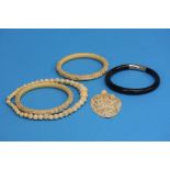 Two ivory bangles, a pierced ivory pendant, an ivo