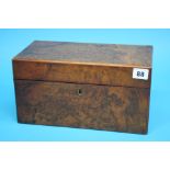 A Victorian walnut tea caddy opening to reveal gla