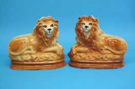 A pair of recumbent Staffordshire lions, 24cm heig