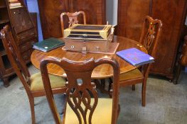 A reproduction circular mahogany dining table and