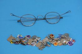 A silver charm bracelet and a pair of old spectacl