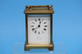 A small brass carriage clock with enamelled dial,