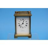 A small brass carriage clock with enamelled dial,