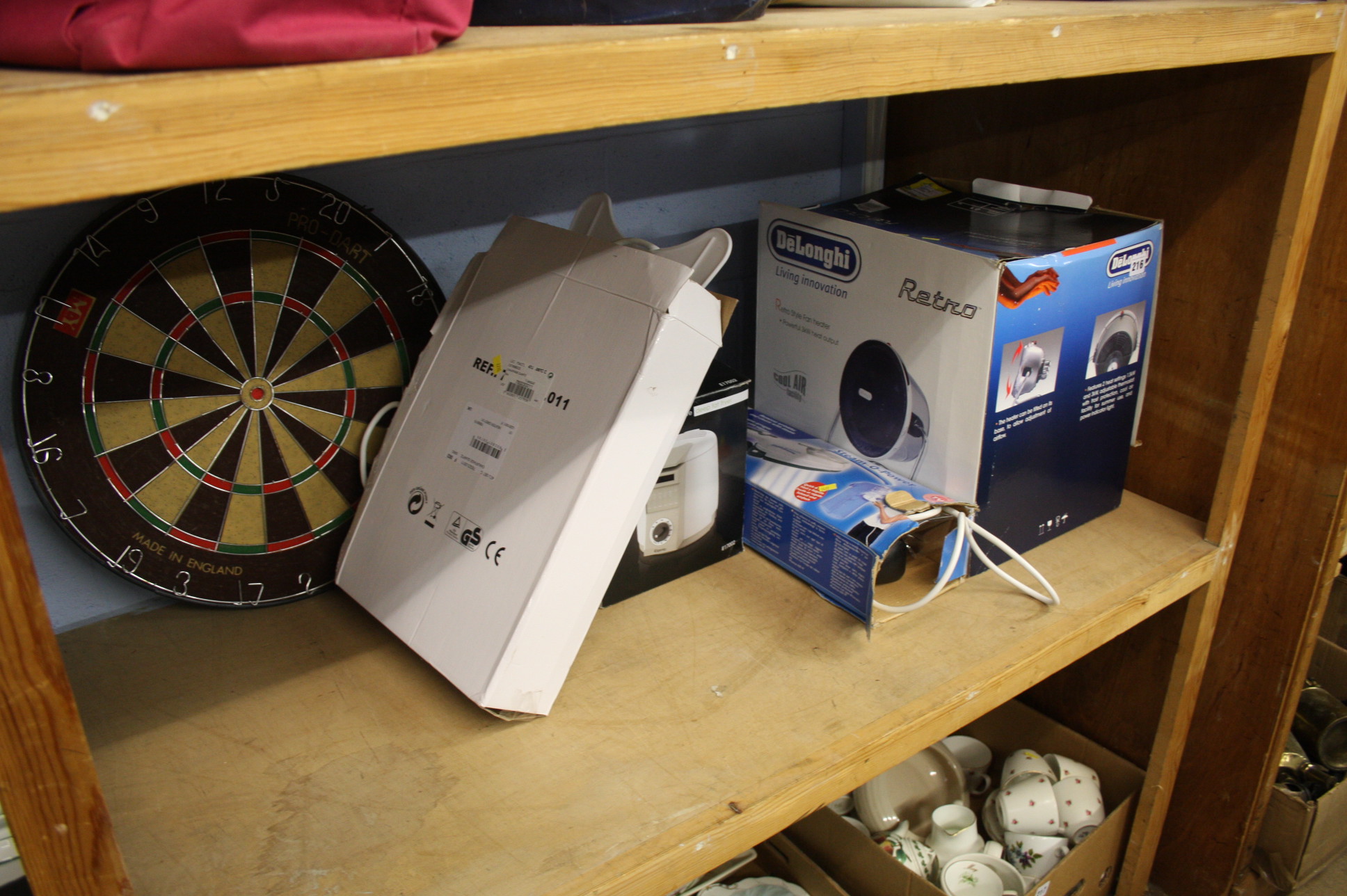 Shelf of assorted including dartboard etc.