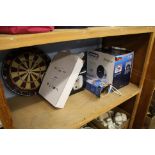 Shelf of assorted including dartboard etc.