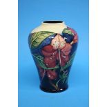 A modern Moorcroft vase of tapering form on a dark