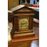 An oak cased German chiming mantle clock, the bras