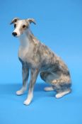 A Winstanley seated lurcher. 32cm height