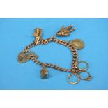 A 9ct gold bracelet with padlock fastener and a collection of charms, weight 29.9gm