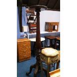 A tall mahogany plant stand with circular top, fluted and reeded central column, supported on