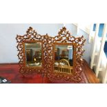 A pair of metalwork easel mirrors with ornate foli