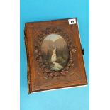 A Victorian carved walnut fronted photograph album