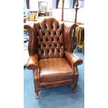 A Chesterfield brown leather button back armchair