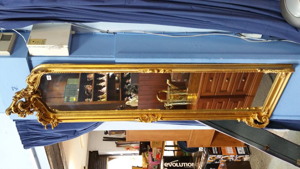 A gilt narrow decorative mirror.