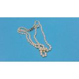 A pearl necklace tie clasp with baguette cut centr