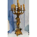 A decorative gilt metal cherub lamp, the cherub holding aloft a seven sconce light