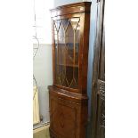 A reproduction walnut corner cabinet