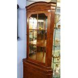 A reproduction walnut corner cabinet