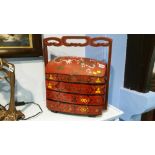 An Oriental lacquered 3 tier container with carrying handles