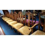 A set of walnut Queen Anne style dining chairs with shell carved legs and paw feet, comprising six