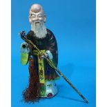 A Chinese enamelled white metal figure of man with a staff, 18cm tall