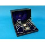 A cased pair of plated toast racks and silver napkin rings