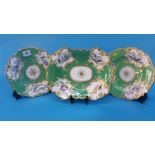 Three Rockingham style porcelain plates, decorated on an apple green ground with panels of birds and