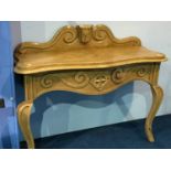 A carved pine serpentine fronted side table