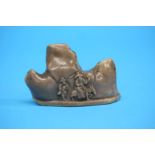 A 19th Century soapstone brush rest, carved as a mountain with figures. 10 cm wide