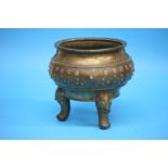 A large Chinese bronze censer, decorated with symbols and supported on three elephant feet. 26 cm