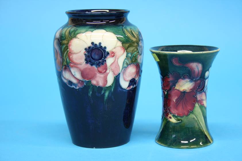 A Moorcroft vase on a blue ground, decorated with pansies and another on green ground decorated with