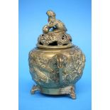 An Oriental bronze censer and cover decorated with birds within a landscape and bearing a Shishi dog