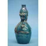 An Oriental double gourd shaped vase on a blue ground with entwined dragon. 24cm high