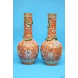 A pair of tall Chinese coral ground vases, decorated with enamelled painted flowers and Chilong